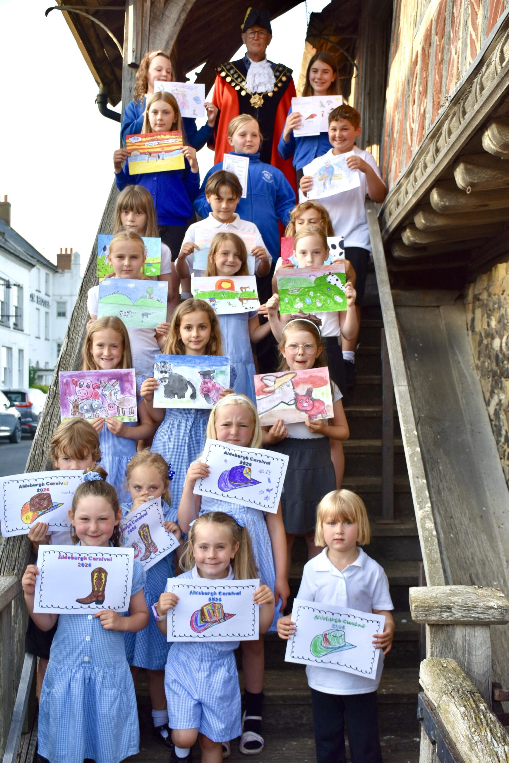 Children from Aldeburgh Primary School holding their Carnival poster competition artwork